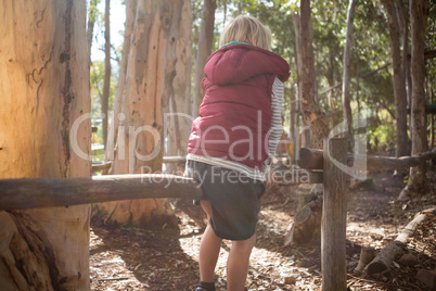 Little girl sitting on log of wood