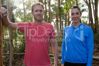 Man and woman trainer standing together in forest