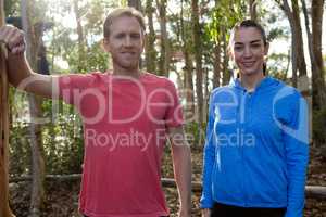 Man and woman trainer standing together in forest