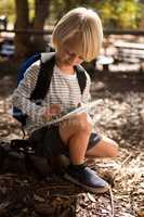 Little girl with a backpack using a tablet
