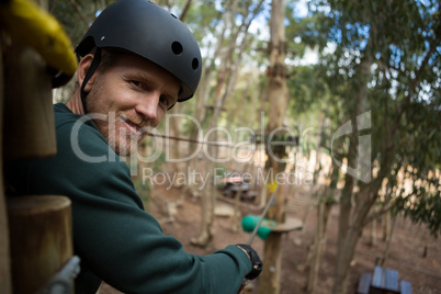 Portrait of smiling man wearing safety helmet looking into camera in the forest