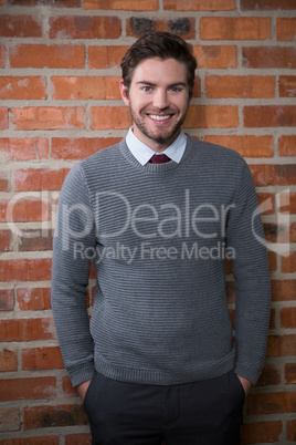 Smiling executive standing with hands in pocket