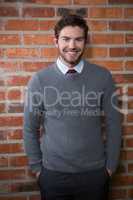 Smiling executive standing with hands in pocket