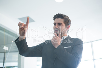 Thoughtful businessman touching invisible digital screen