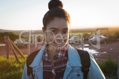 Woman standing with backpack at countryside