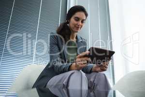 Low angle view of female executive using digital tablet