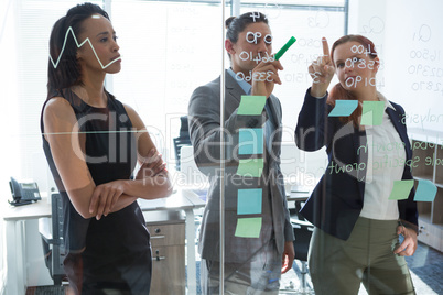 Group of executives discussing over information on the wall