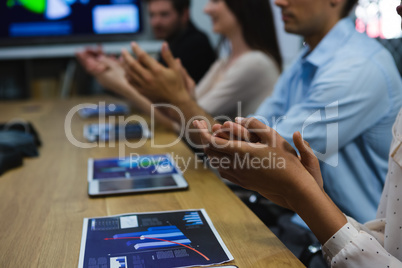 Business colleagues clapping hands in meeting
