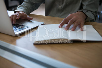 Male executive working at desk with laptop