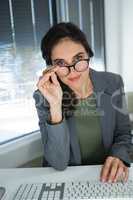 Beautiful female executive in spectacles working at desk