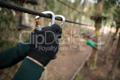 Two male hands with hand gloves holding carabiner