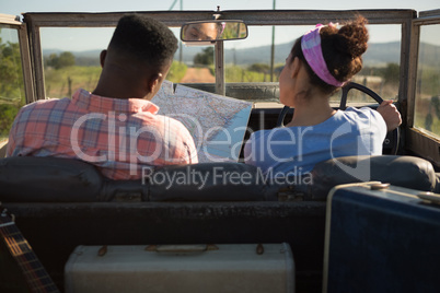 Couple looking at map while sitting in car