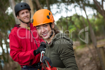 Young hiker couple holding zip line in forest during daytime
