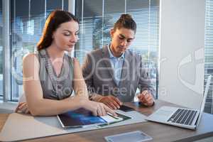 Business executives discussing over documents at desk