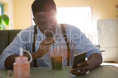 Man using mobile phone while having drinks