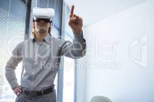 Male executive gesturing while using virtual reality headset