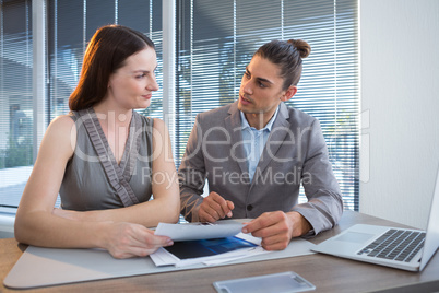 Business executives discussing over documents at desk