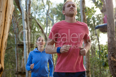 Man and woman jogging in forest