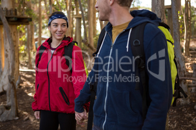 Man and woman with backpack holding hands on a sunny day