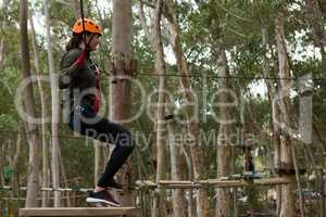 Young woman crossing through a zip line
