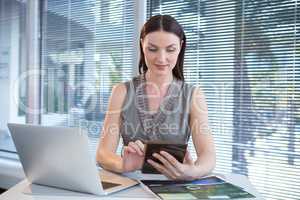 Female executive using digital tablet at desk