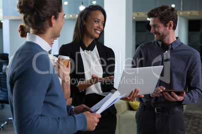 Business colleagues discussing over laptop