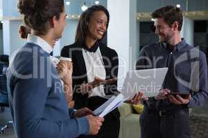 Business colleagues discussing over laptop