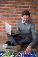 Executive using laptop while looking at document