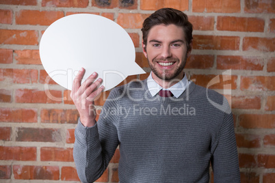 Executive holding a speech bubble in the office