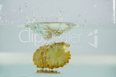 Slices of pineapple falling into the water