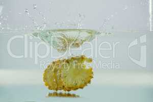 Slices of pineapple falling into the water
