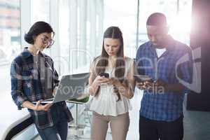 Male and female executives using electronic gadgets