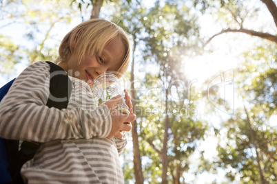 Little girl holding jar with plant