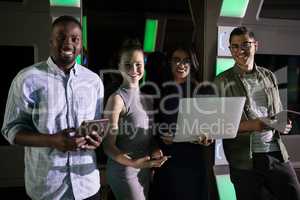 Portrait of business executives standing with laptop and digital tablet