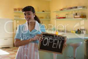 Waitress showing slate with open sign in restaurant