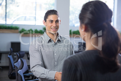 Male executive shaking hands with woman