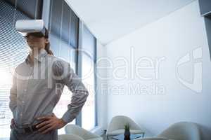 Male executive using virtual reality headset in waiting area