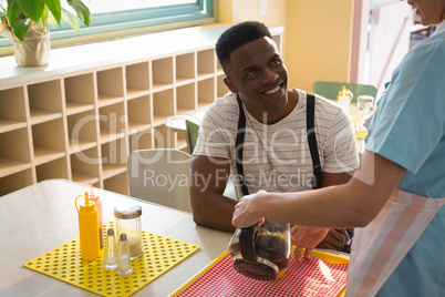 Waitress serving black coffee to man