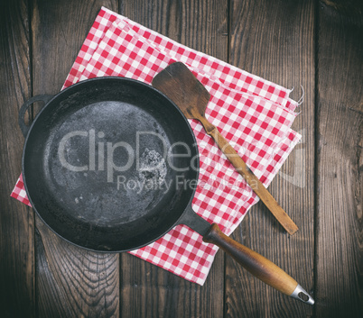 empty black round frying pan with a wooden handle