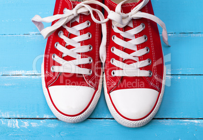 a pair of red textile sneakers with white laces
