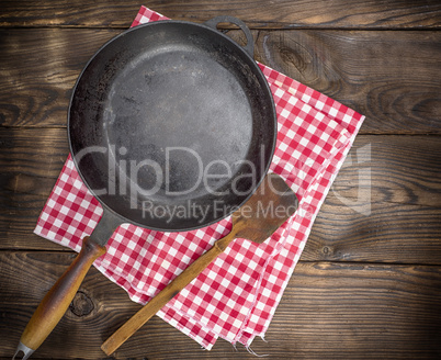 empty black round frying pan with a wooden handle