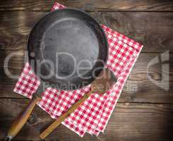 empty black round frying pan with a wooden handle