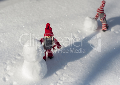 Two toy little men playing in the snow