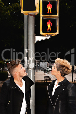 Trendy young couple looking at the traffic light.