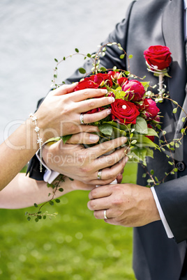 Bride and groom holding bridal bouquet