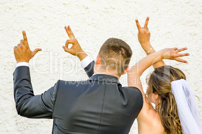 Bride and groom show with the fingers Love
