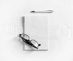Notebook, glasses and pen