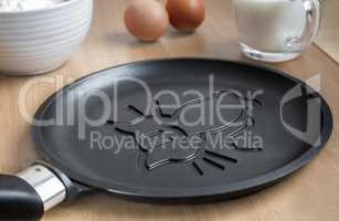 Cast-iron frying pan with ceramic coating and pancake.