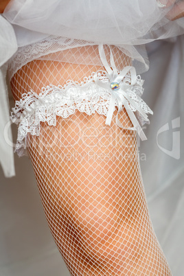 A white lace Garter on the leg of a bride
