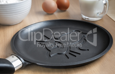 Cast-iron frying pan with ceramic coating and pancake.